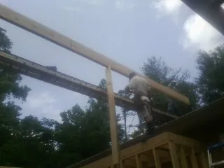 Carpenter setting a ridge beam over a new addition frame — Ice Dam Removal by Roofing Brothers in Stromsburg
