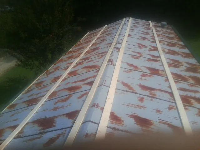 Rusted metal roof panels with new wood purlins before replacement — Storm Damage Roof Repair in Stromsburg by Roofing Brothers
