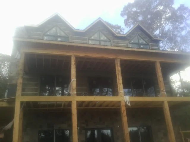 Dormers and porch framing on a large log home under construction — Roof Coating work by our crew in Stromsburg