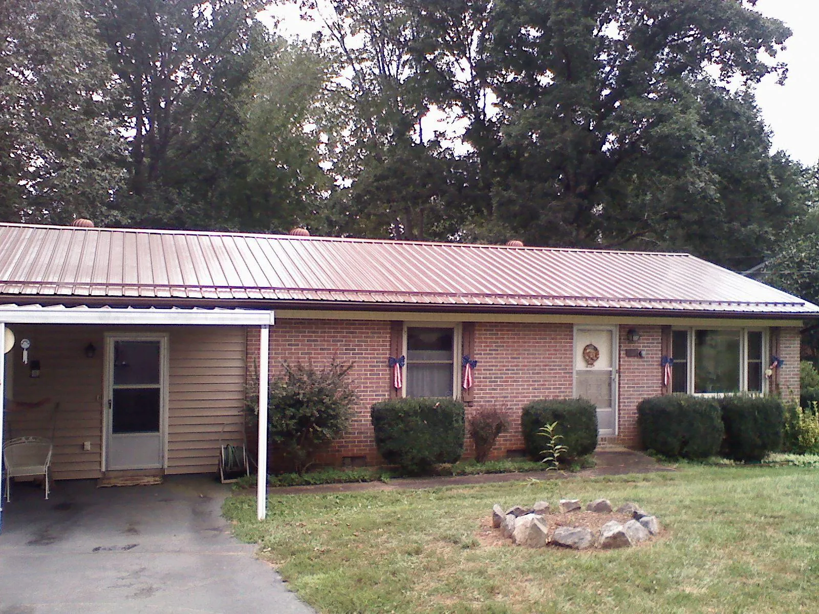 Bronze metal roof and carport on a brick ranch home — Roof Repair work by our crew in Stromsburg